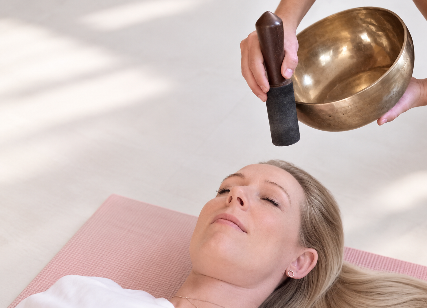 Sound therapy session with Tibetan singing bowls placed around the body